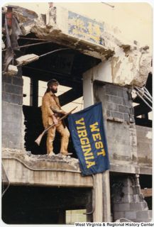 WVU Mountaineer standing on old building